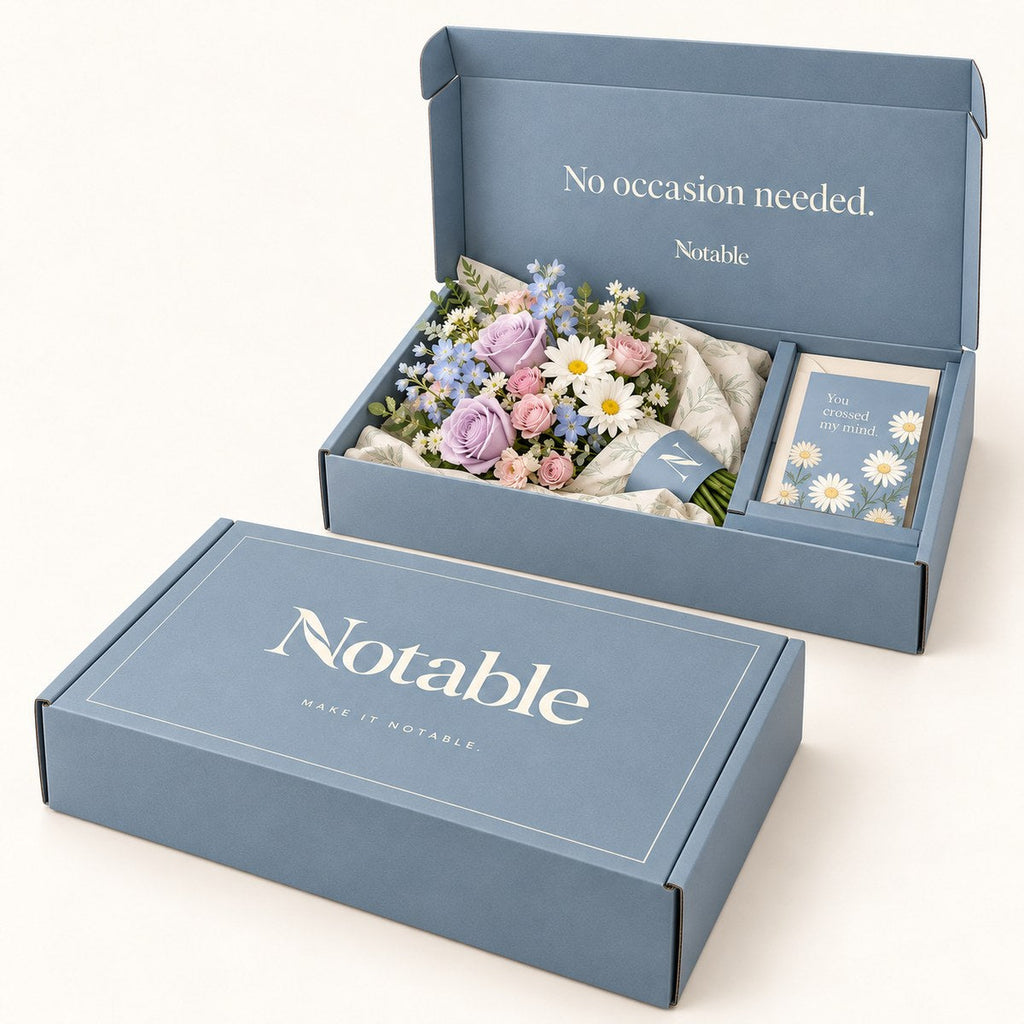 A Lovely Detour bouquet in its dusty blue Notable box, closed box and open box